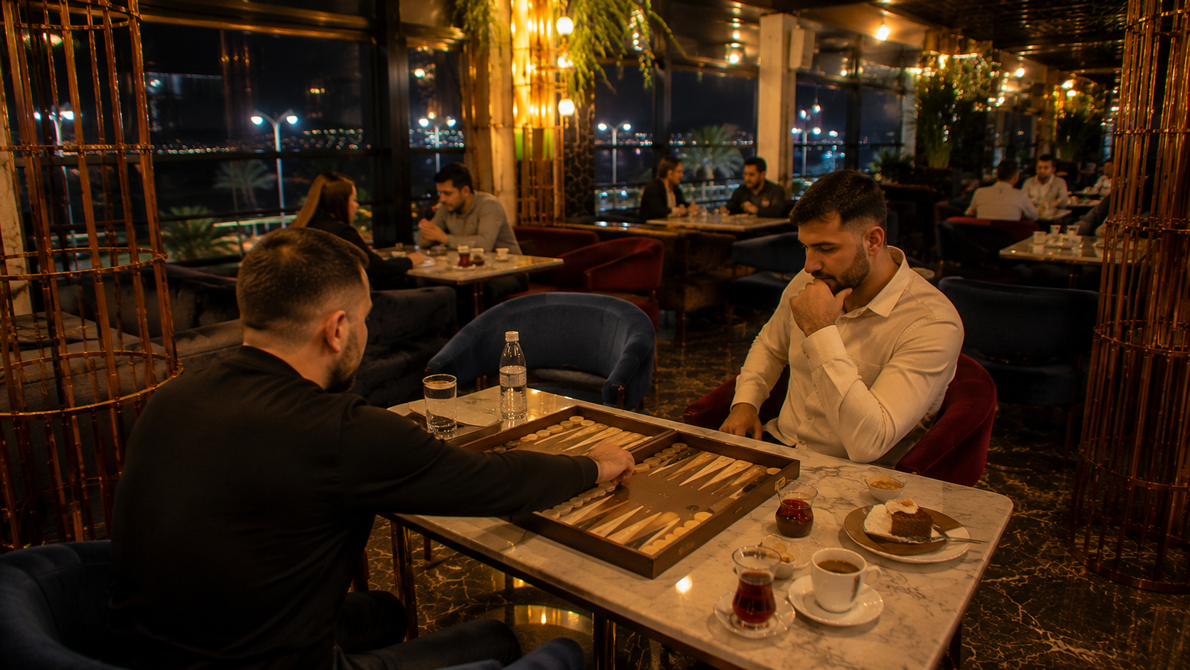 Velora Lounge'un farklı bir bölümünde doğal şekilde tavla oynayan iki misafir, masada çay ve kahve eşliğinde sıcak ve gerçek restoran atmosferi.