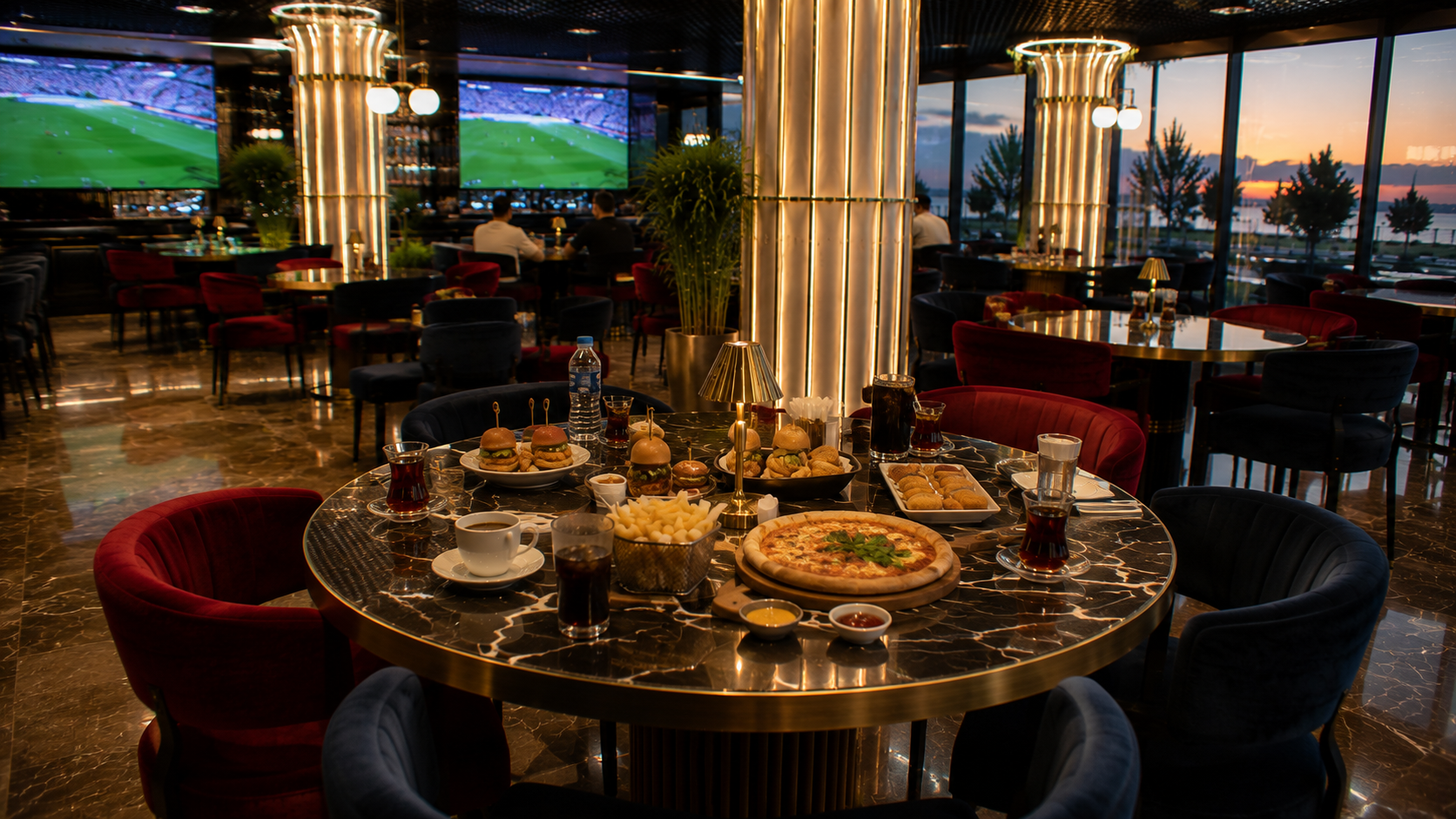 Maltepe derbi maçı izleme için büyük ekranın görüldüğü modern lounge ortamında hazırlanmış masa, atıştırmalıklar, içecekler ve futbol yayınına hazır konforlu oturma düzeni.