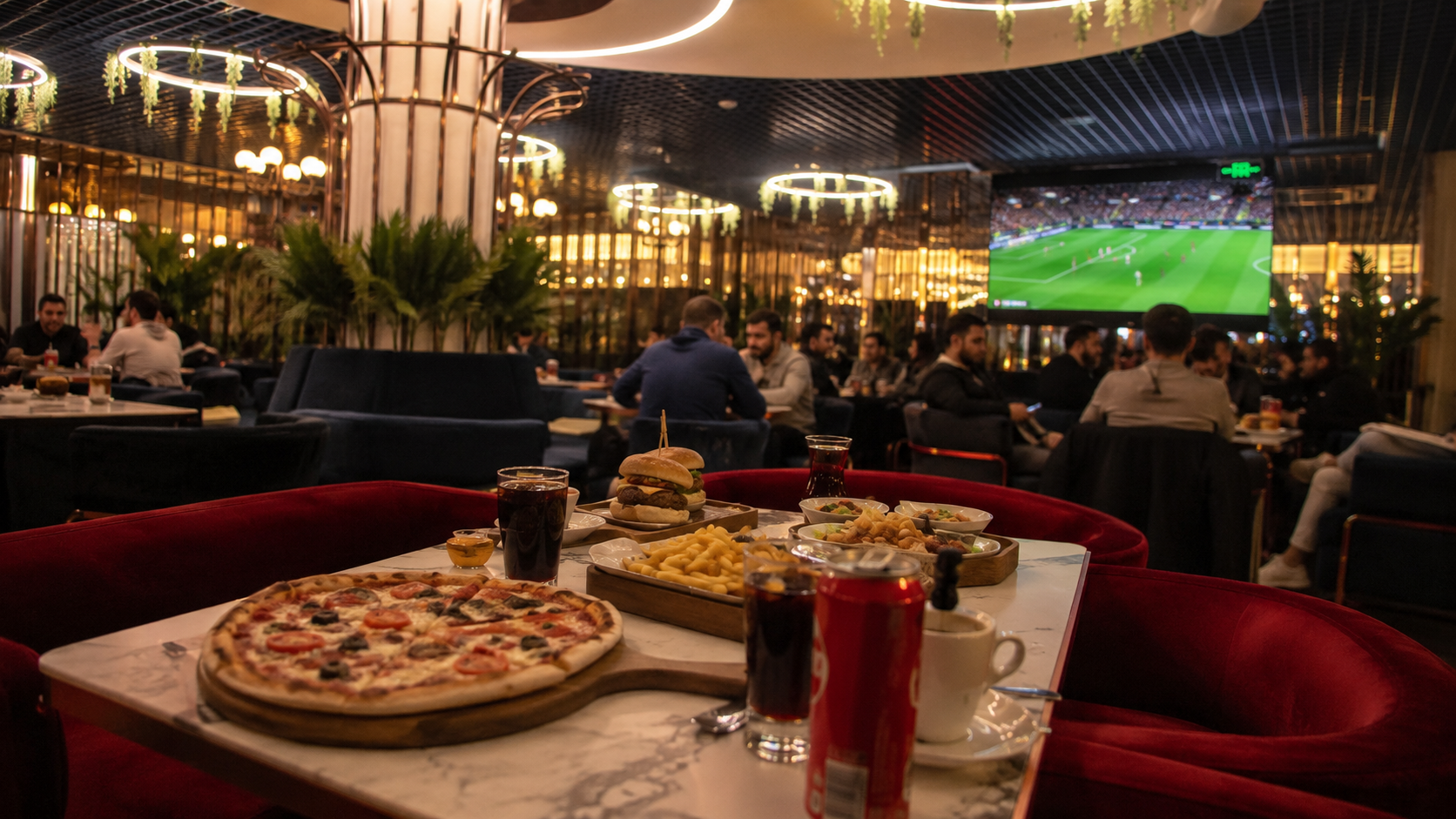 Maltepe'de derbi maçı yayını sırasında büyük ekranı gören modern lounge restoranında doğal akşam atmosferi, hazırlanmış masa ve futbol yayını deneyimi.