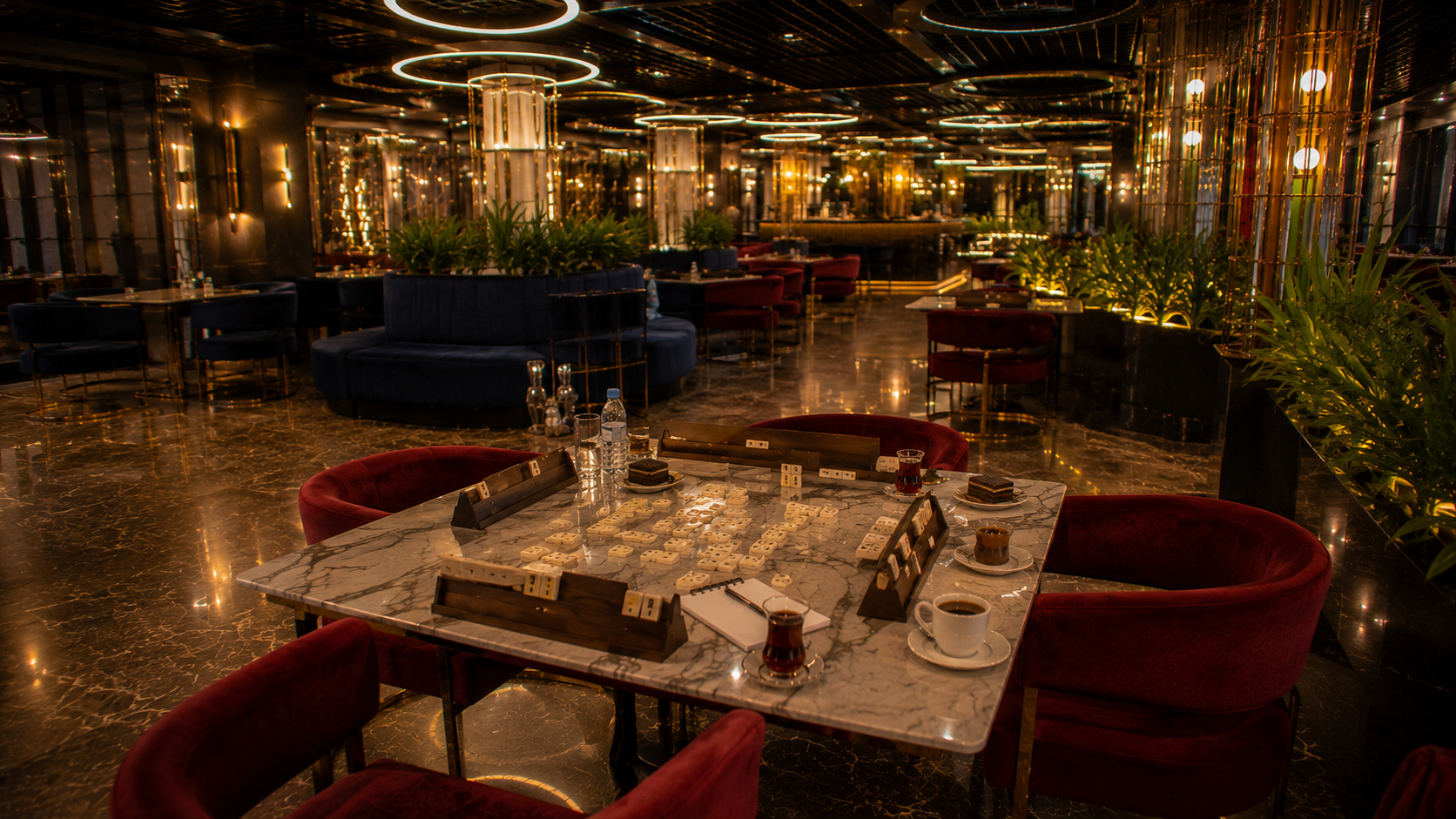 Velora Lounge içerisinde sahile yakın atmosferde hazırlanmış geniş mermer masada 101 oyunu düzeni, okey taşları, çay ve kahve sunumlarıyla gerçekçi lounge ortamı.